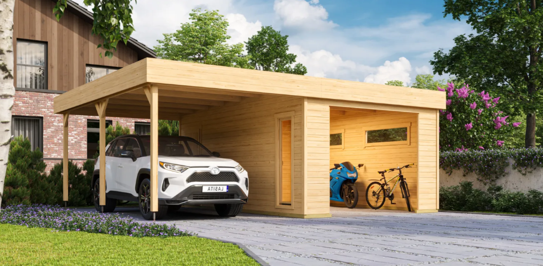 Ein weißes Auto steht unter einer Garage aus Holz. Direkt mit dieser verbunden befindet sich eine Garage, in der ein weißes Fahrrad und ein blaues Motorrad stehen.