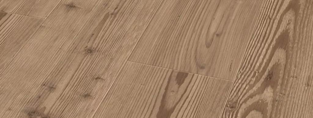 Das Bild zeigt einen Bodenbelag aus Vinyl mit einem hellbraunen Finish. Die Dielen sind horizontal angeordnet und weisen unterschiedliche Maserungen auf, die gut sichtbar sind. Einige natürliche Knoten und Linien ziehen die Oberfläche durch, was dem Material ein rustikales Aussehen verleiht. Die Textur des Bodens variiert sanft in Ton und Struktur, wodurch ein vielseitig einsetzbares Design entsteht, das sich für verschiedene Einrichtungsstile eignet. Dieser Vinylboden bietet eine optisch attraktive Alternative zu traditionellen Holzfußböden und kombiniert praktische Pflegeeigenschaften mit einer ästhetischen Ästhetik für Wohn- oder Geschäftsräume.