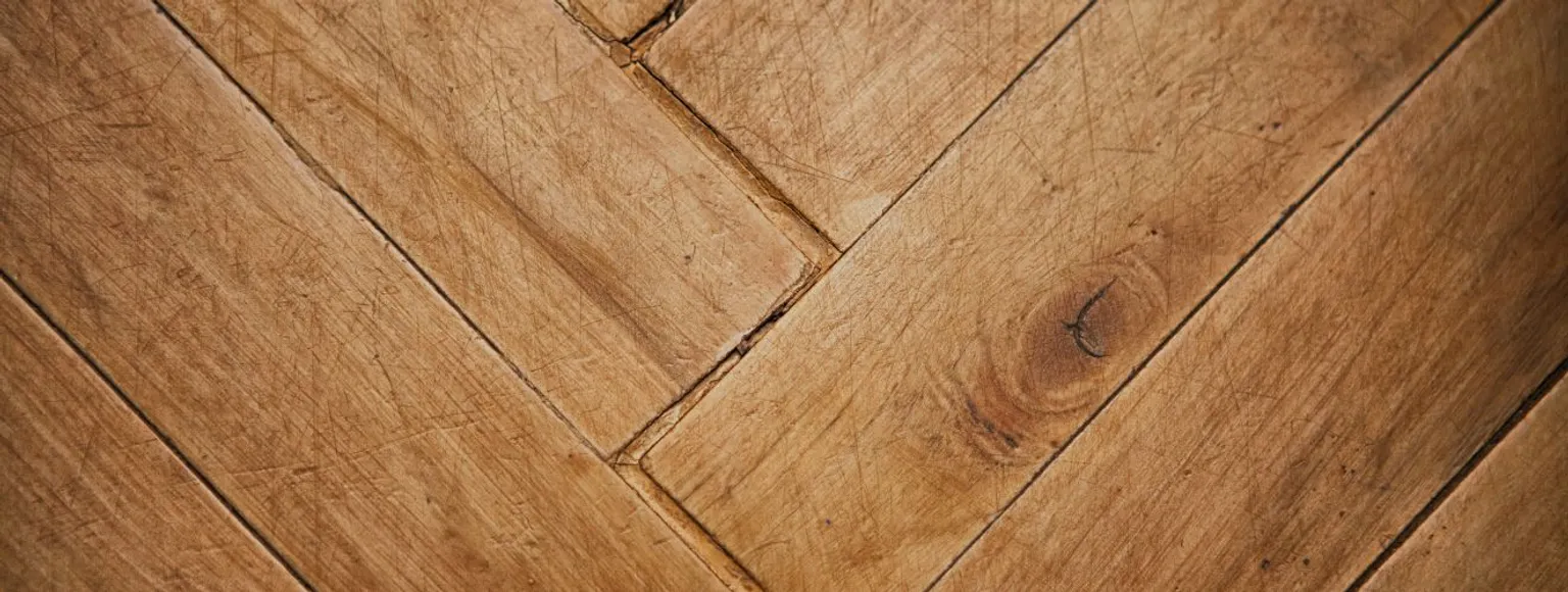 Detailansicht des Fischgrätenparketts nach gründlicher Reinigung, natürliche Holztöne sichtbar.
