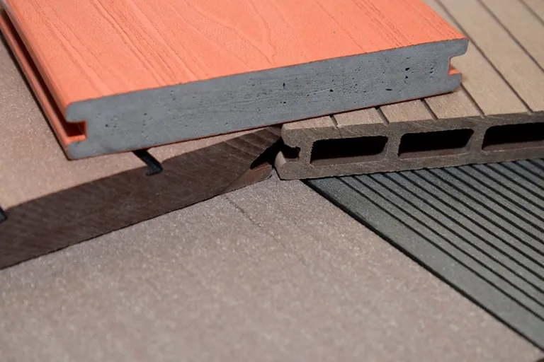 Detailansicht von WPC-Dielen mit unterschiedlichen Profilen und Oberflächenstrukturen bei neutraler Beleuchtung.