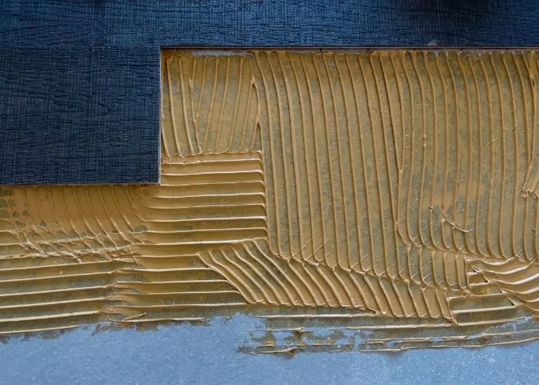Die alte Wandverkleidung mit sichtbarem Kleber wird entfernt, um den neuen Bodenbelag vorzubereiten.