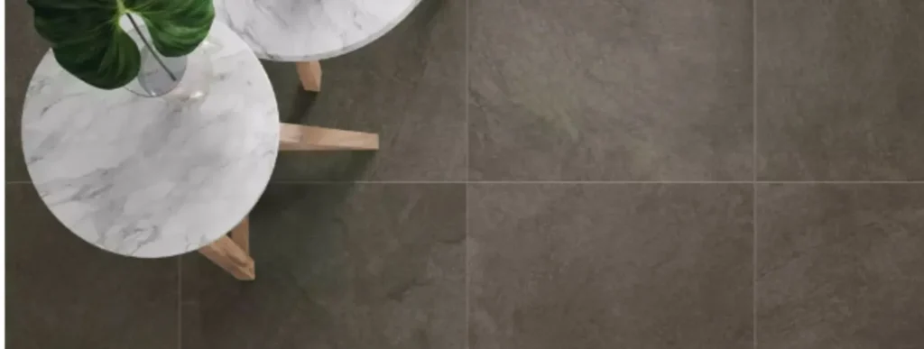 Draufsicht auf zwei Marmortische mit Holzbeinen auf hellgrauen DryTile-Bodenfliesen.