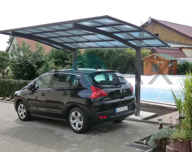 Ein schwarzes Fahrzeug, geparkt unter einem Carport mit Flachdach, Metallstützen und gepflastertem Boden.