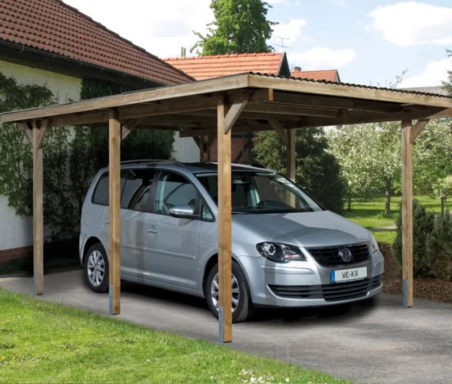 Ein silbernes Auto ist unter einem hölzernen Carport neben einem Haus geparkt, mit sichtbarer Beschilderung.