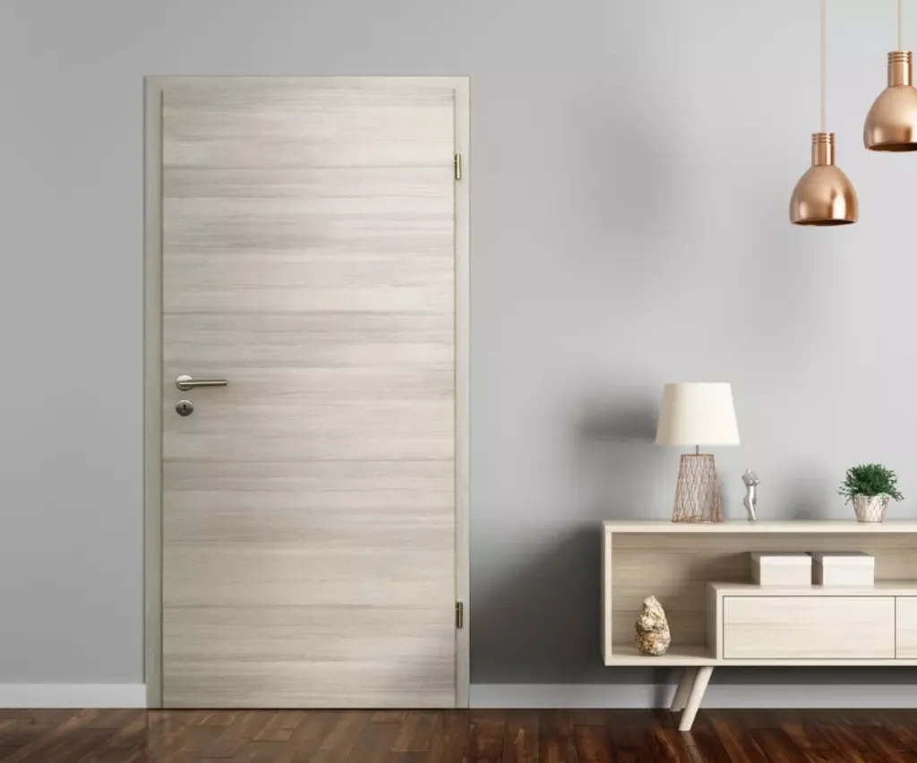 Geschlossene Innentüren aus hellem Holz neben einem modernen Konsolentisch mit Dekor und Lampen.