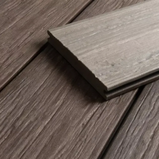 Gestapelte, koextrudierte Terrassendielen mit brauner Holzstruktur in einer Nahaufnahme.