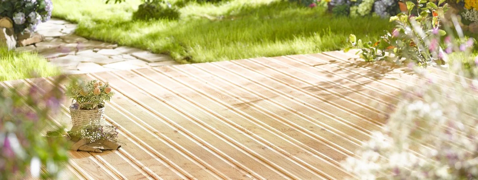 Helle Nadelholz-Terrassendielen auf Holzdeck im Garten bei Sonnenschein.