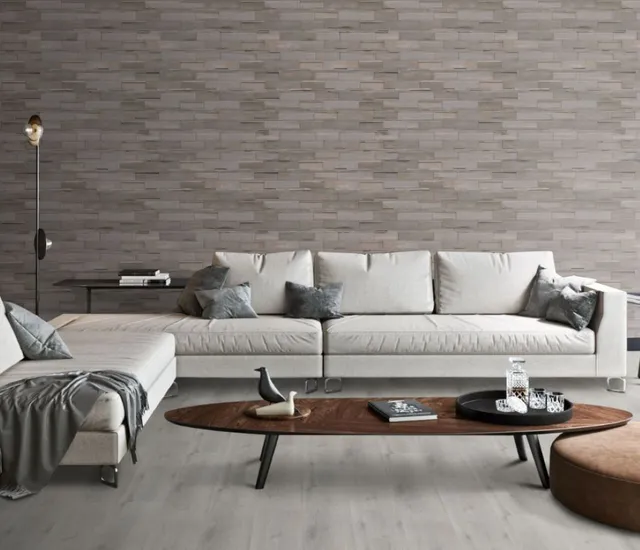Helles Wohnzimmer mit hellen Wandpaneelen, Sofa, Tisch und dekorativen Pflanzen.