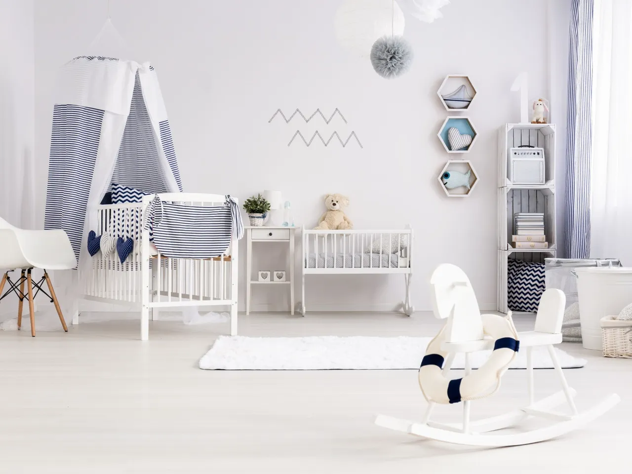 Kinderzimmer mit weißem Kinderbett, Holzschaukelpferd, Wandregalen und Korkfußboden.