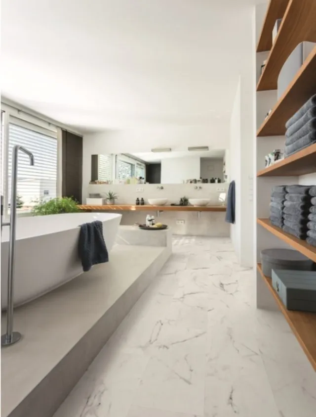 Modernes Badezimmer mit freistehender Badewanne, Vinylboden und Regalen mit Handtüchern.