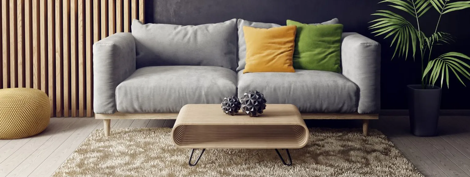 Modernes Wohnzimmer mit hellem Boden, Sofa, Couchtisch und dekorativen Elementen.