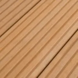Nahaufnahme von hellbraunen Hartholz-Terrassendielen mit parallelen Rillen und sichtbarer Textur.