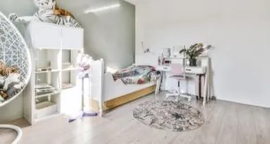 Schlafzimmer mit hellen Wänden, einem Schreibtisch, einem Bett, einem Stuhl und einem Vinylboden in einem modernen Interieur.
