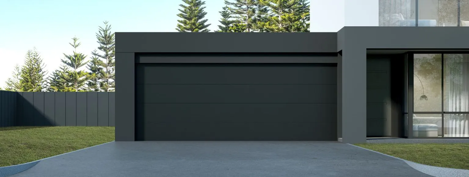 Schwarzes Garagen-Sektionaltor in einem minimalistischen Haus mit Bäumen und Glasfenstern.