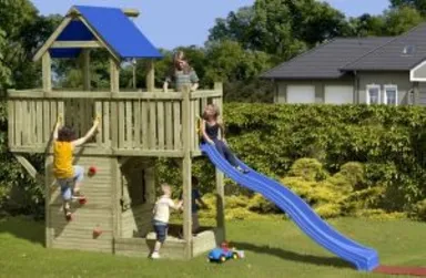 Vier Kinder spielen auf einem Spielplatz im Freien mit einer Rutsche und einer Kletterwand.