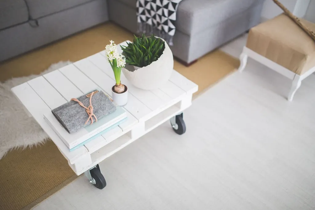 Weißer Couchtisch aus Paletten in einem modernen, kleinen Wohnzimmer mit hellem Dekor.