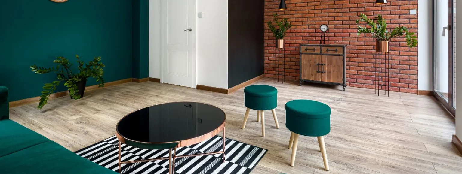 Wohnzimmer mit grünen Wänden, Korkfußboden und modernen Möbeln in neutralen Tönen.