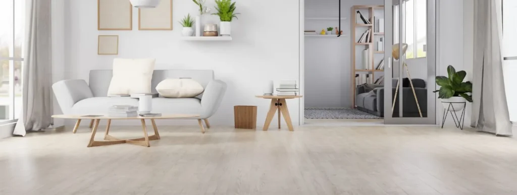 Wohnzimmer mit Korkfußboden, weißen Wänden, Sofa kleinem Tisch.