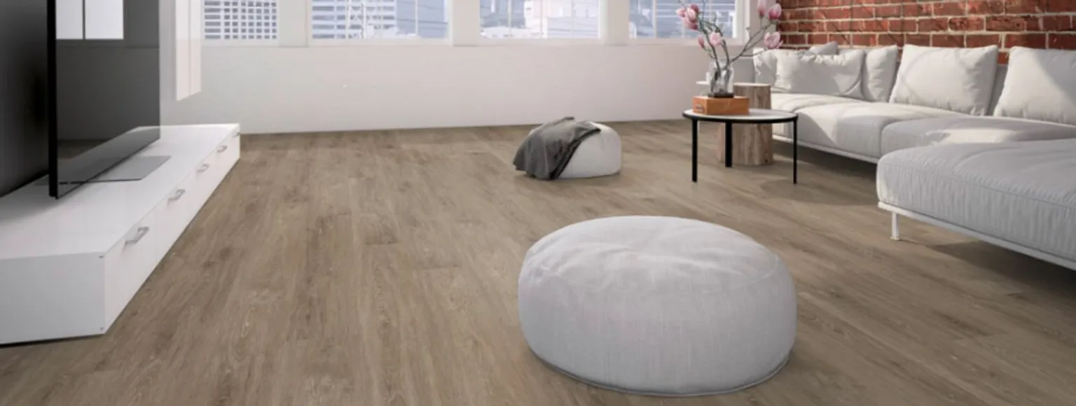 Wohnzimmer mit Vinylboden, weißem Sofa und großen Fenstern, die natürliches Licht hereinlassen.