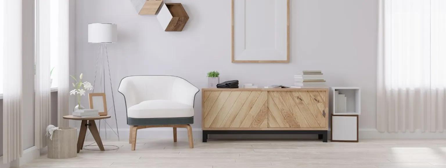Wohnzimmer mit weißem Stuhl, Holzschrank und Laminatfußboden in neutralen Tönen.