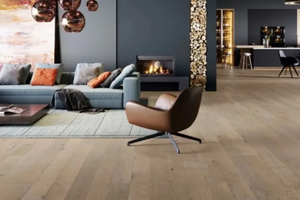 Wohnzimmer mit Holzboden, Kamin, blauem Sofa und Möbeln in neutralen Tönen.