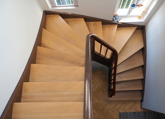 Draufsicht auf eine Holztreppe mit Vinylstufen umgeben von schlichten weißen.