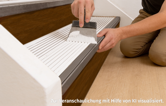 Person, die mit einem Werkzeug Klebstoff auf eine Holztreppe aufträgt.