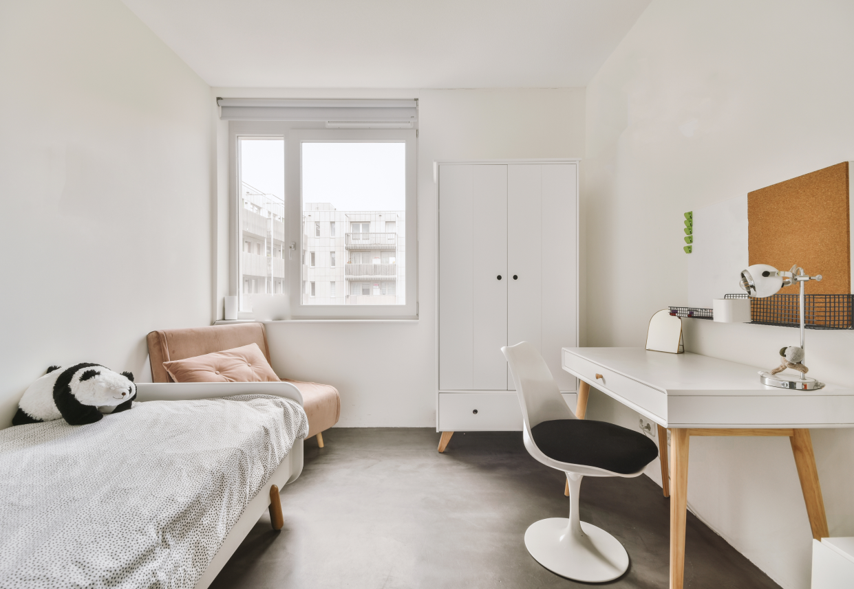 Modern eingerichtetes Kinderzimmer mit Betonoptik, schlichtem Schreibtisch und gemütlichem Lesesessel – das Bild ist klickbar und führt direkt zum passenden Boden im casando-Shop