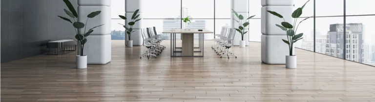 Konferenzraum mit hellem Bodenbelag, langem Holztisch, Stühlen.
