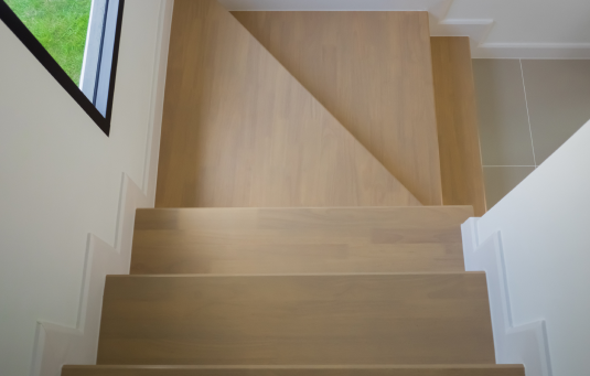 Moderne Treppe mit hellbraunem Parkettboden – Blick von oben auf die gleichmäßig verkleideten Stufen mit klarer Holzmaserung und sauberen weißen Setzstufen. Bild ist klick bar und führt zum passendem Parkett