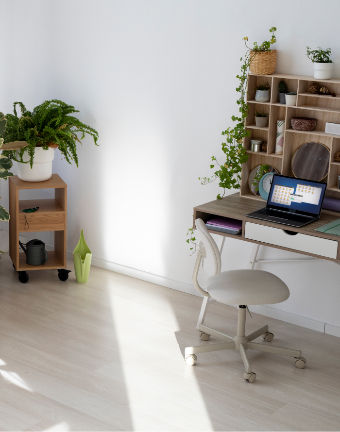 Heimbüro mit Korkparkettboden, weißem Stuhl, Schreibtisch, Grünpflanzen und hellen Wänden.
