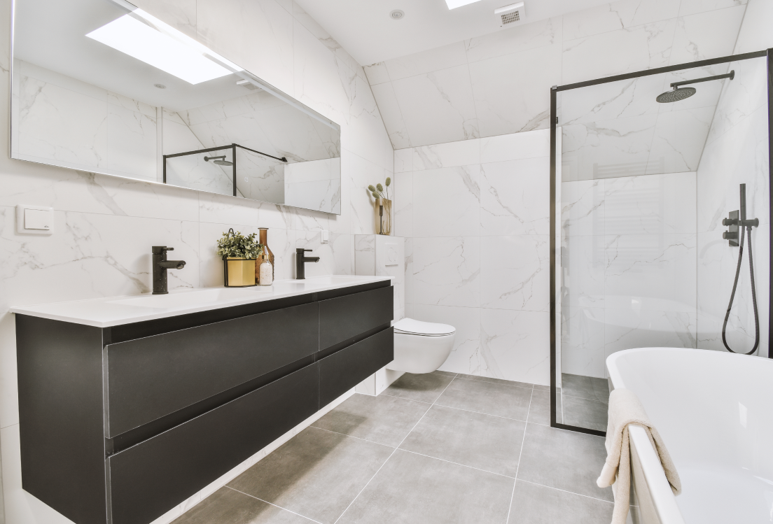 Helles, modernes Badezimmer mit großformatigen Wandfliesen in Marmoroptik und grauem Feinsteinzeugboden – stilvoll, zeitlos und pflegeleicht. Jetzt klicken und passende Fliesen im casando-Shop entdecken.