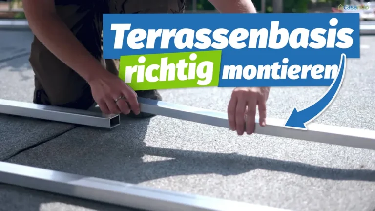 Zwei Hände beim Zusammenbau eines Terrassenrahmens mit Blick auf die deutsche Montageanleitung.
