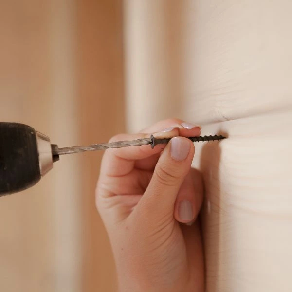 Eine Person bohrt eine Schraube in die Wand