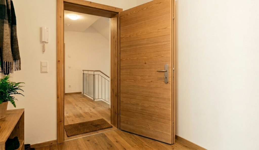 Reine braune Wohnungseingangstür steht geöffnet zwischen Wohnung.